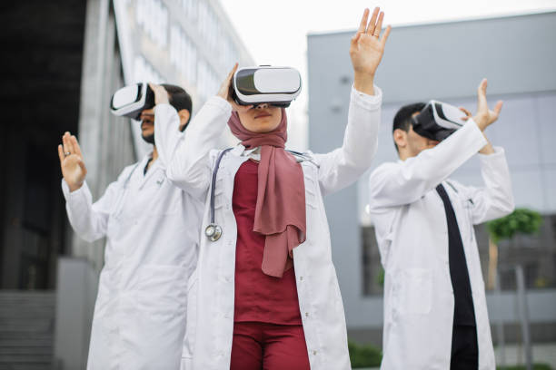 istock Three focused Arabian doctors, wearing VR headset, moving hands in the air, standing outside 1335258554