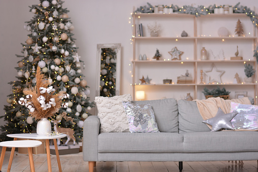 Sala de estar moderna de Navidad con árbol de Navidad, sofá, estante con decoraciones navideñas. Feliz año nuevo y feliz navidad photo