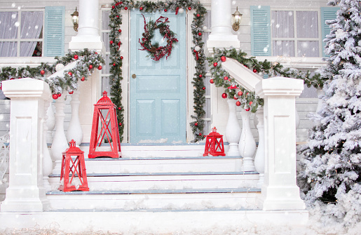 Christmas porch.Snowy courtyard with Christmas porch, veranda, wreath, Christmas tree, garland,christmas balls and lanterns. Merry Christmas and Happy New Year