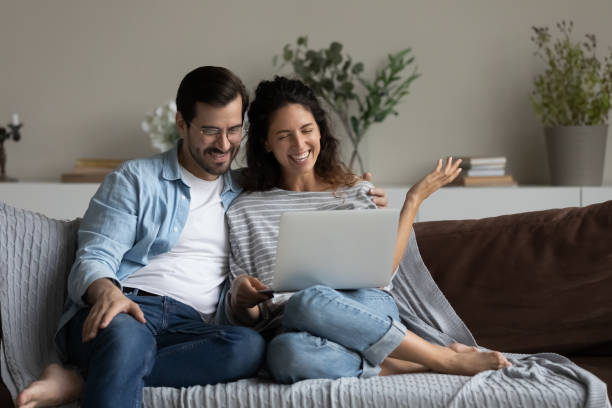 istock Happy millennial couple using laptop for video call from home 1335262749