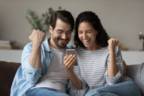 istock Excited joyful family couple using smartphone, looking at screen 1335262753