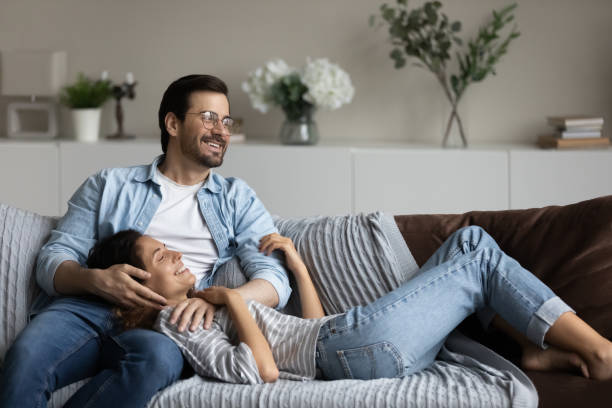 istock Happy millennial couple relaxing on soft comfortable couch at home 1335262770