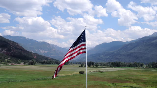 American Flag Flying in an Open Field In The Mountains