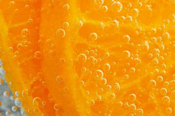 istock Orange slice and ice cubes with bubbles in cold carbonated drink. 1335264920