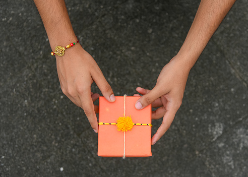Raksha Bandhan, Indian festival with beautiful Rakhi on red background. A traditional Indian wrist band which is a symbol of love between Sisters and Brothers.