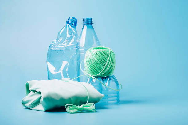 istock Empty plastic bottle and various fabrics made of recycled polyester fiber synthetic fabric on a blue background 1335269266
