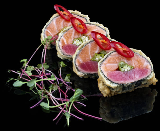 istock Large sushi roll with salmon, tuna and caviar on glossy black background 1335273680