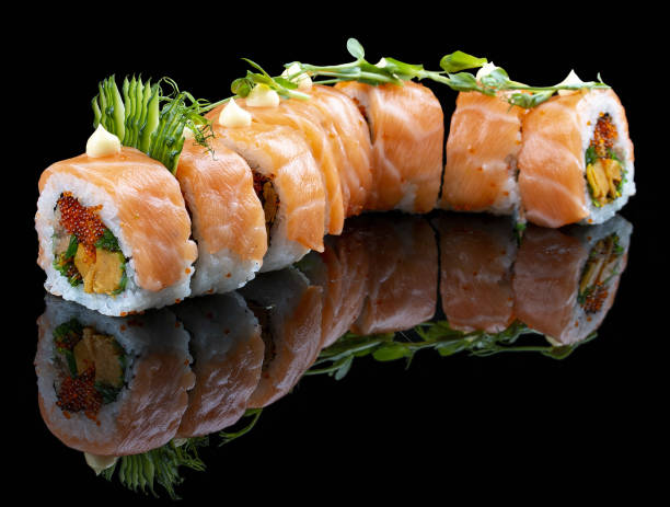istock Red Dragon roll with salmon, avocado and tobiko on glossy black background 1335273701