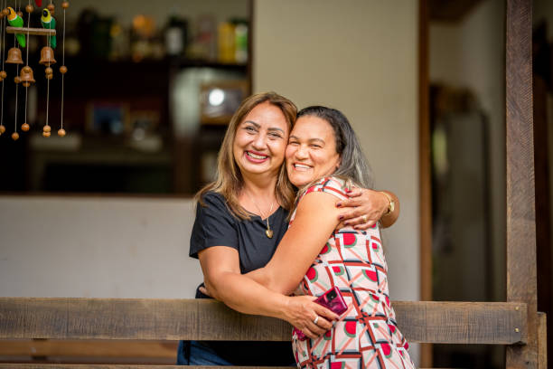istock Smiling female friends hugging each other during a visit 1335274725