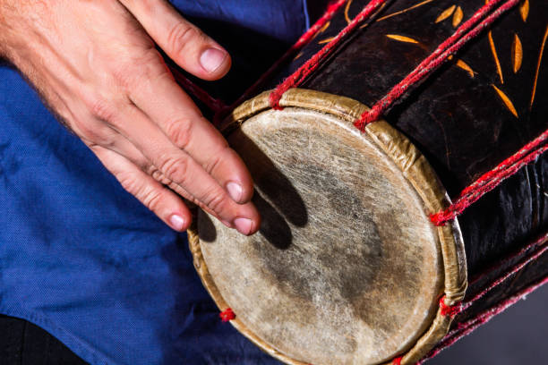 istock Man is drumming on wooden ethnic drum 1335276904