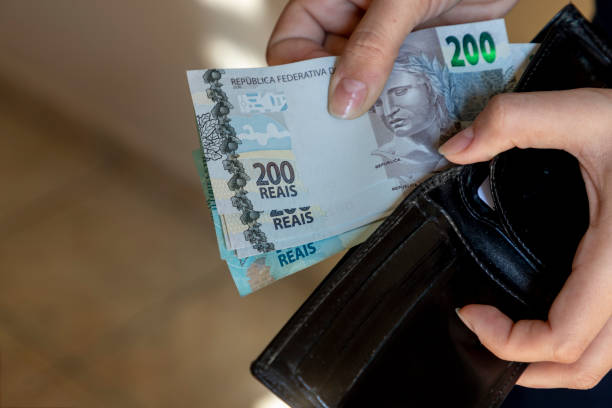 woman putting brazilian money bills from her wallet. - home economics class imagens e fotografias de stock