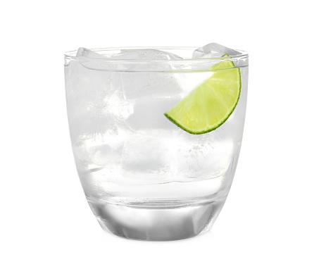 Glass of refreshing drink with ice cubes on white background