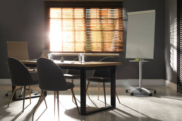 istock Stylish office interior with wooden table and flipchart 1335282151