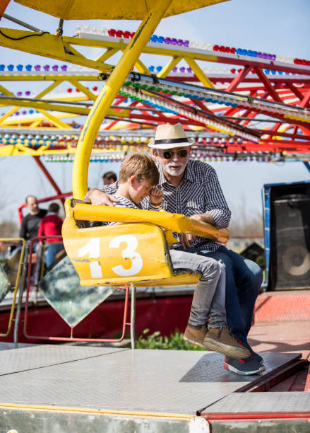 istock Grandfather and grandson hawe fun in amusement park. 1335282446