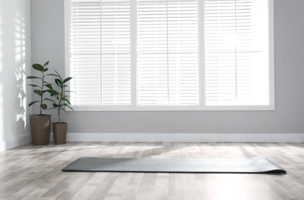 istock Unrolled grey yoga mat on floor in room 1335282534