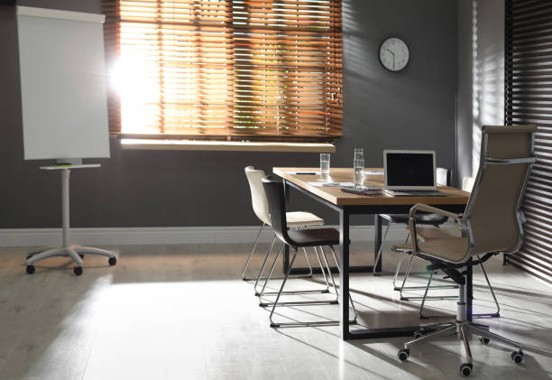istock Stylish office interior with wooden table and flipchart 1335282580