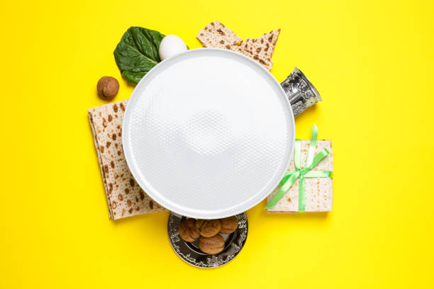 cadre réalisé avec des éléments symboliques de la pâque sur fond jaune, espace pour le texte. célébration de pesah - seder passover seder plate matzo photos et images de collection