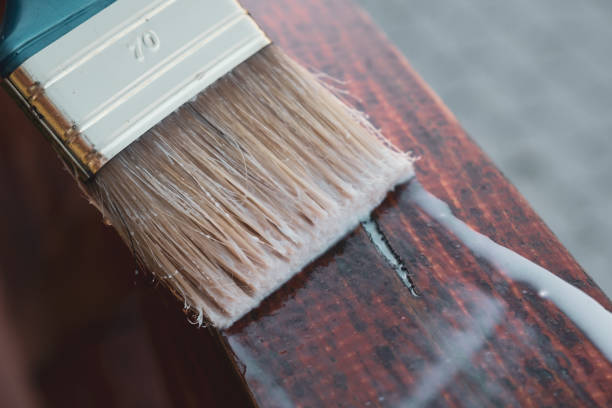 istock Paintbrush in hand applying protective coat on the wooden surface 1335283262