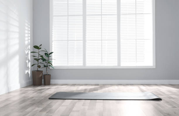 istock Unrolled grey yoga mat on floor in room 1335283365