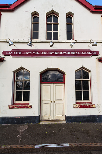 Llanfairpwllgwyngyll, Llanfair Pwllgwyngyll or Llanfair­pwllgwyngyll­gogery­chwyrn­drobwll­llan­tysilio­gogo­goch sign on railway station building. Anglesey, Wales, portrait