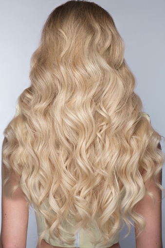 A closeup view of a bunch of shiny curls blond hair.