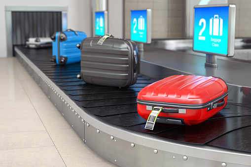 Baggage claim in airport terminal. Suitcases on the airport luggage conveyor belt.
