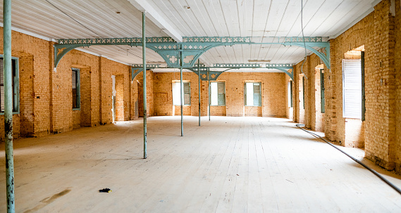 Interior of a large empty historic warehouse with brick walls being prepared for a restoration