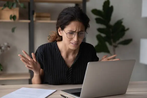 Photo of Close up upset businesswoman in glasses having problem with laptop