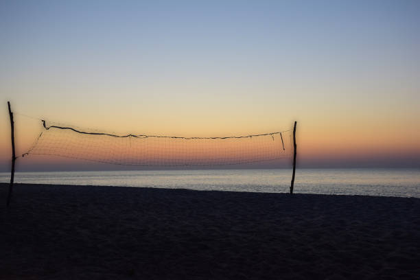 istock On the evening empty beach, volleyball net at sunset background 1335295805