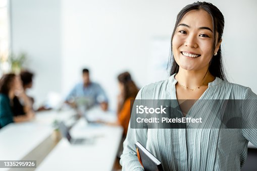 istock Asian Businesswoman Standing Smiling at the Camera 1335295926