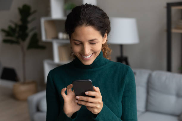 istock Close up smiling woman using smartphone, typing on screen 1335296843
