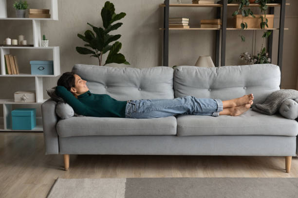 istock Full length smiling woman resting on cozy couch at home 1335296864