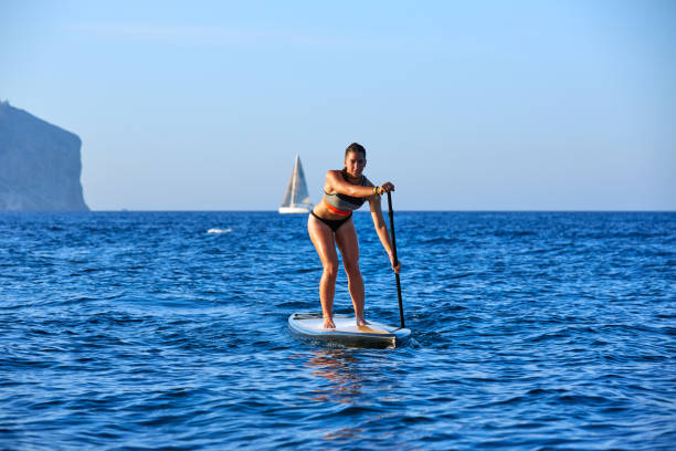 istock SUP Stand up Surf girl with paddle 1335300898