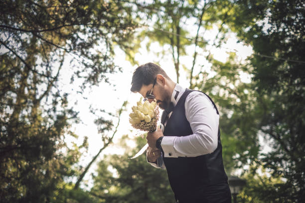 Groom holding a bridal bouquet