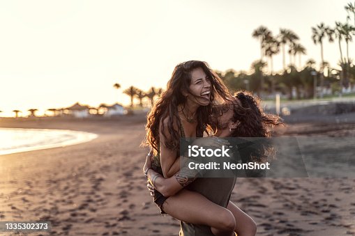 istock Happy beautfiul italian couple having fun together on the beach, laughing. Sunset time. 1335302373