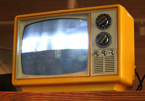 Photo of a yellow retro CRT television.