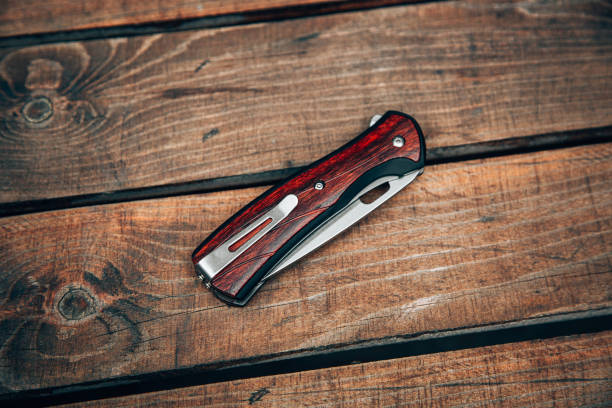istock Folding pocket knife with wooden handle. A small knife on a wooden surface. 1335305186