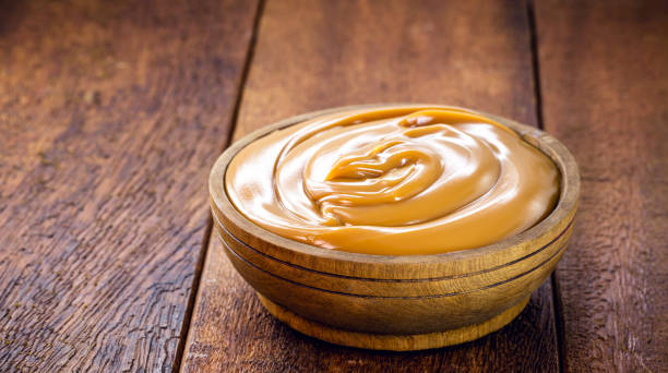 pot of dulce de leche or homemade caramel on rustic wooden background, typical Brazilian sweet pot of dulce de leche or homemade caramel on rustic wooden background, typical Brazilian sweet dulce de leche stock pictures, royalty-free photos & images