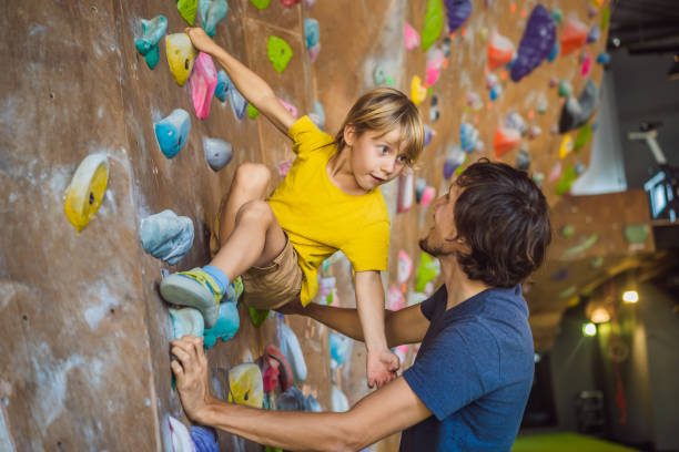 papá e hijo en el rocódromo. deporte familiar, estilo de vida saludable, familia feliz - clambering fotografías e imágenes de stock