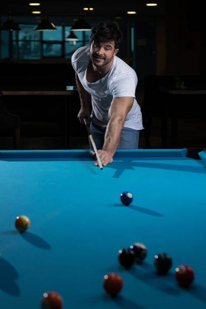 istock Young Man Lining To Hit Ball On Pool Table 1335316499