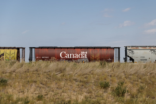 Claresholm, Alberta - July 4, 2021: Railcars, farms and industrial equipment alongside the highways of southeast Alberta