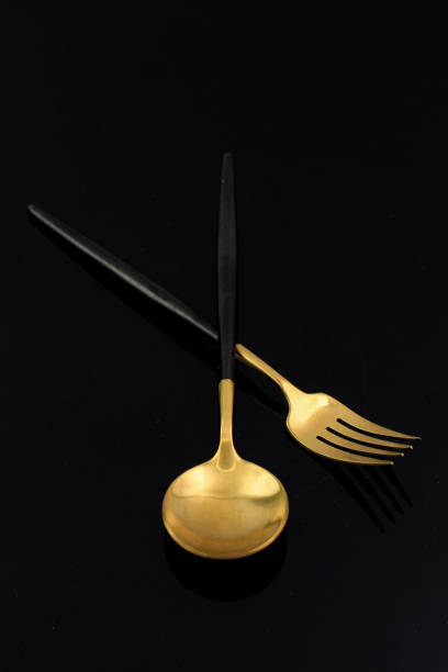 istock Golden Spoon and Fork Isolated on Black 1335321253