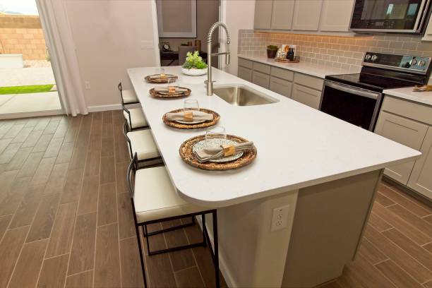 istock Kitchen Island With Four Place Settings, Sink And Stools 1335328444