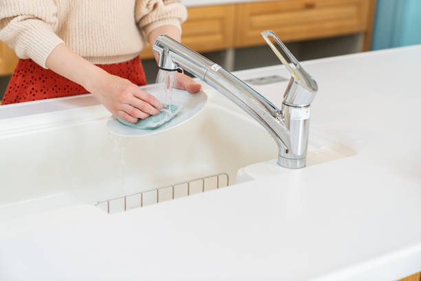 istock woman washing the dishes in a kitchen, hands 1335328564