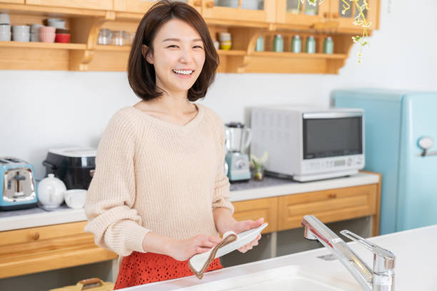 キッチンで皿を洗う魅力的なアジアの女性 - 家庭用 ストックフォトと画像