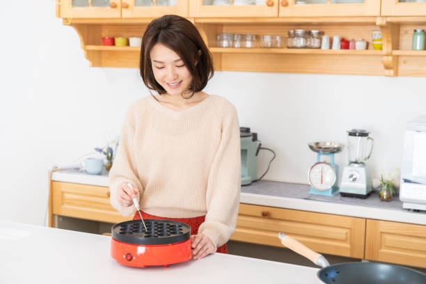 istock young asian woman baking Takoyaki in a kitchen ,Octopus balls, 1335329679
