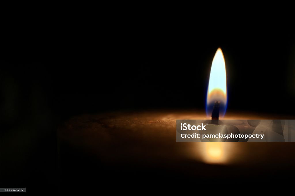 Isolated glowing candle on black background - stock photo Closeup isolated candle glowing in pitch darkness. Candle Stock Photo