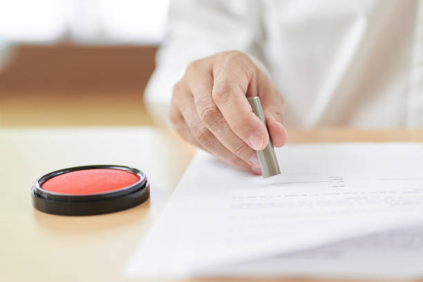 istock Hands of elderly people who stamp their contracts 1335345498
