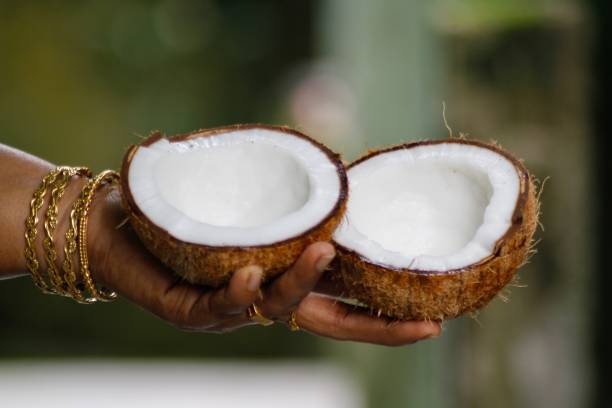 istock A women's hand holding opened coconut 1335352622