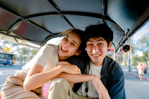 Young Asian couple spends a day in a car in the Bangkok city on vacation.